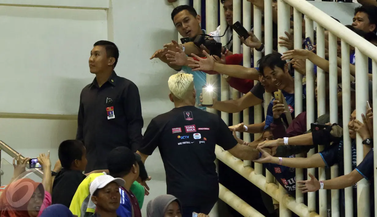 Suporter Arema FC berebut menyalami Cristian Gonzales saat merayakan kemenangan atas PBFC di final Piala Presiden 2017 di Stadion Pakansari, Kab Bogor, Minggu (12/3). Arema FC juara Piala Presiden 2017. (Liputan6.com/Helmi Fithriansyah)