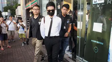 Polisi Hong Kong mengamankan seorang staff saat razia di kantor Uber Inc, Selasa (11/8/2015). Dalam razia ini polisi mengamankan 5 orang yang tertangkap basah memberikan jasa pelayanan sebagai sopir taxi dengan kendaraan ilegal. (REUTERS/Apple Daily)