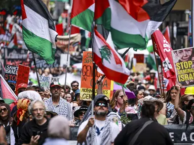 Para demonstran pro-Palestina membawa bendera, spanduk, dan plakat saat mereka berbaris berunjuk rasa di jalanan kota Sydney, Australia, Minggu 22 Februari 2026. Ribuan demonstran pro-Palestina kembali berkumpul memenuhi salah satu ruas jalan di Sydney, Australia. (DAVID GRAY/AFP)