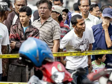 Sejumlah orang berkerumun di lokasi ledakan bom Kampung Melayu, Jakarta Timur, Kamis (25/5). Lokasi terjadinya ledakan bom dipadati warga untuk berfoto dan melihat langsung peristiwa yang menewaskan tiga polisi tersebut. (Liputan6.com/Faizal Fanani)