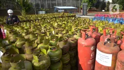 Petugas mengecek tabung LPG bersubsidi  yang diamankan di Jakarta, Jumat (15/7/2022). Sebanyak, 3.344 tabung gas non subsidi yang dijual di pasaran  sebagai barang bukti yang telah diamankan bersama 14 tersangka. (merdeka.com/Imam Buhori)