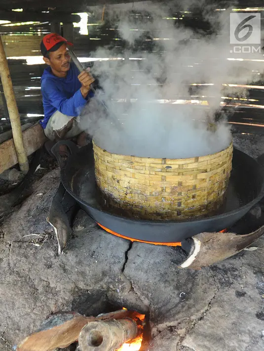 Seorang pria memasak air nira kelapa yang akan dijadikan gula merah di desa Taman Jaya, Sukabumi, Jawa Barat  (24/06). Gula kelapa ini berasal dari pengolahan nira kelapa. (Merdeka.com/Arie Basuki)