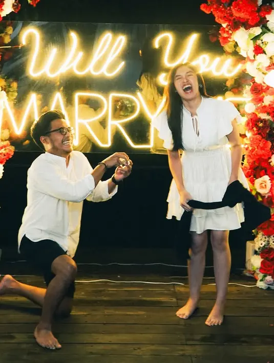 Ochi tampak mengenakan mini dress ruffle putih dengan lengan pendek dengan aksen pita pada bagian dada. Sedangkan kekasihnya mengenakan kemeja putih lengan panjang dipadukan celana pendek hitam. [@ochi24]