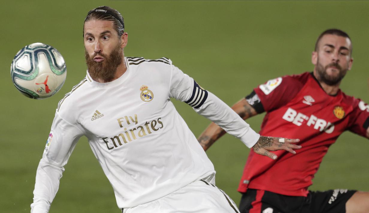 Bek Real Madrid, Sergio Ramos, berebut bola dengan pemain Real Mallorca, Dani Rodriguez, pada laga La Liga di Stadion Alfredo Di Stefano, Kamis (25/6/2020). Real Madrid menang 2-0 atas Real Mallorca. (AP/Bernat Armangue)