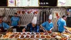 Karyawan sebuah restoran mengenakan kaus Manchester City dan Inter Milan jelang final Liga Champions di Istanbul, Turki, Jumat (9/6/2023). Manchester City akan menghadapi Inter Milan dalam duel perebutan gelar juara Liga Champions di Ataturk Olympic Stadium, Istanbul, Turki, pada 11 Juni 2023 pukul 02.00 WIB. (Umit Turhan Coskun/AFP)