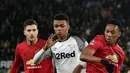 Pemain Manchester United Anthony Martial (kanan) berebut bola dengan pemain Derby County Morgan Whittaker pada pertandingan putaran kelima Piala FA di Pride Park, Derby, Inggris, Kamis (5/3/2020). Manchester United menang dengan skor 3-0. (AP Photo/Rui Vieira)