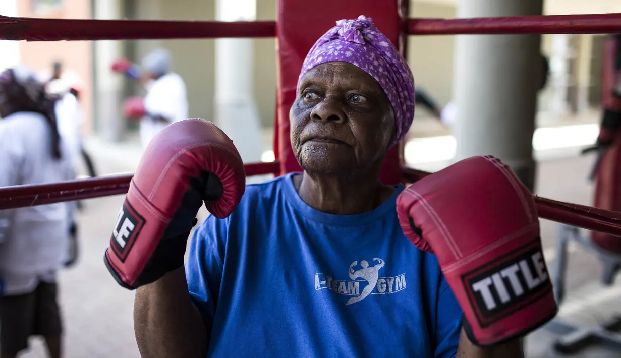 Seorang nenek berlatih tinju pada Boxing Gogos di Cosmo City, Johannesburg, Selasa (19/9/2017). Berkat latihan rutin yang dipimpin Claude Maphosa ini para lansia berhasil sembuh dari penyakit dan hidup lebih sehat. (AFP/Gulshan Khan) 