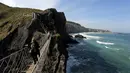 Seorang turis melintasi Jembatan Carrick-a-Rede Rope di Pantai Causeway, Irlandia Utara, Rabu (8/4/2015). Jembatan tersebut diperkirakan telah dibangun selama lebih dari 350 tahun oleh para nelayan salmon. (REUTERS/Cathal McNaughton)