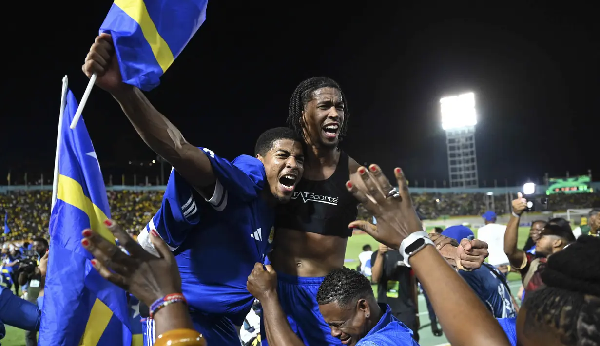 Pemain dan suporter Timnas Curacao merayakan hasil imbang melawan Jamaika pada Grup B Kualifikasi Piala Dunia 2026 zona CONCACAF di Independence Park Stadium, Jamaika pada 18 November 2025. Timnas Curacao memastikan tempat di Piala Dunia 2026. (Ricardo MAKYN/AFP)