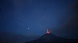 Foto yang diambil dengan exposure yang lama menunjukkan, cahaya bintang menerangi langit berpadu dengan Gunung Sinabung yang sedang memuntahkan lahar di Karo, Sumatera Utara (28/12). (AFP/Lana Priatna)