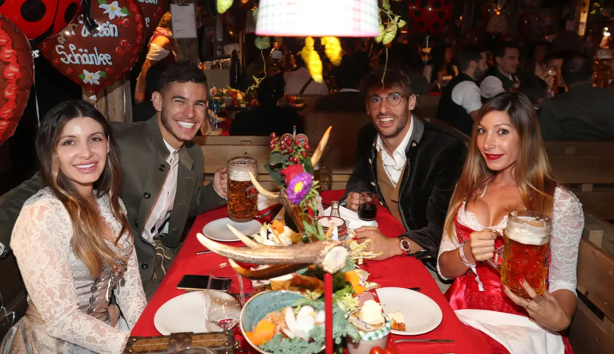 Bek Bayern Munchen, Lucas Hernandez dan pacarnya Amelia bersama gelandang Javier Martinez dan teman wanitanya menikmati bir saat menghadiri festival bir Oktoberfest 2019 di Munich, Jerman selatan (6/10/2019). (AFP Photo/Stefan Matzke)