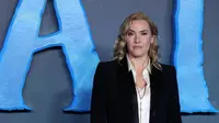 Kate Winslet berpose saat pemotretan untuk film 'Avatar: The Way of Water' di London, Minggu, 4 Desember 2022. Si cantik mengangkat tubuhnya dengan sepasang sepatu bot kulit. (AFP/Isabel Infantes)