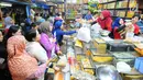 Pedagang kue kering melayani pembeli di Pasar Jatinegara, Jakarta, Senin (27/5/2019). Jelang Idul Fitri 2019, banyak warga berburu makanan ringan seperti kue kering untuk jamuan di hari raya. (Liputan6.com/Angga Yuniar)