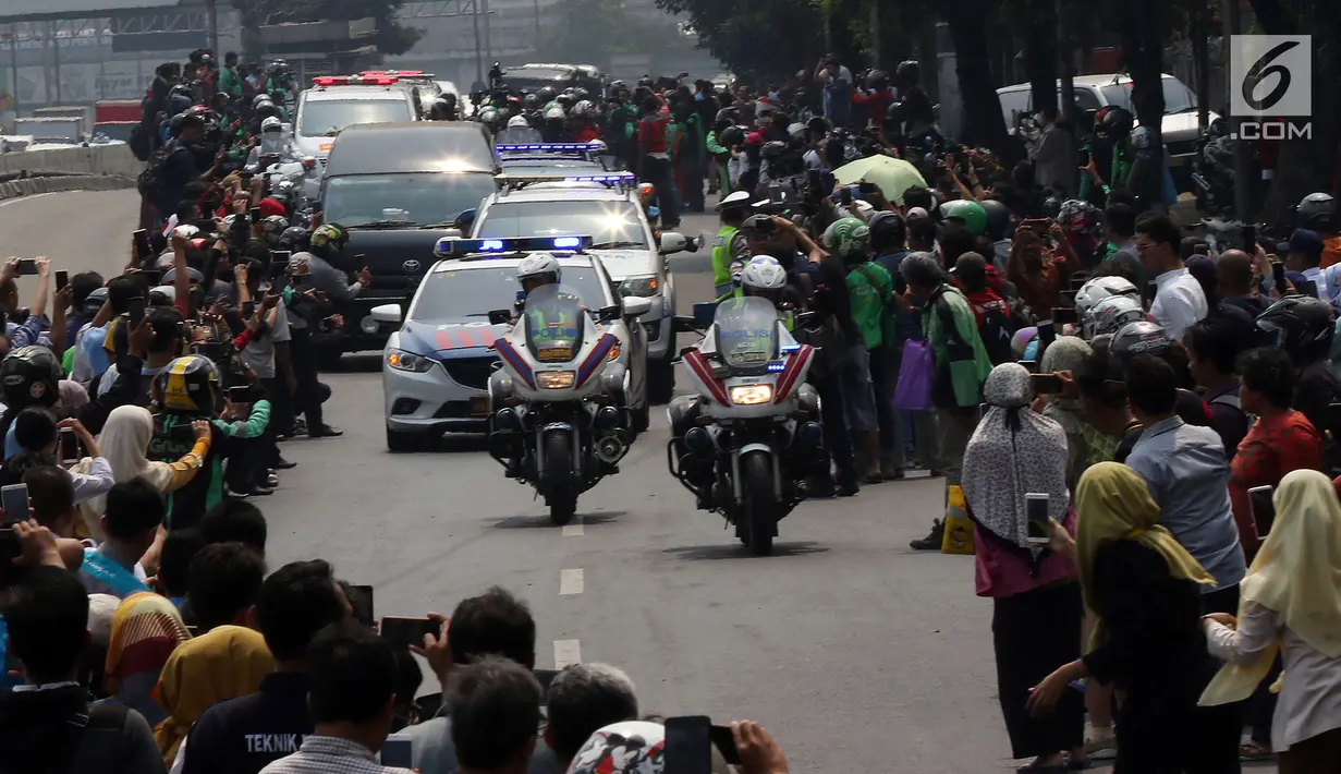 Warga antusias melihat iring-iringan mobil jenazah yang membawa almarhum Presiden ke-3 RI, BJ Habibie saat melintasi Jalan Gatot Subroto menuju TMP Kalibata, Jakarta, Kamis (12/9/2019). BJ Habibie meninggal pada Rabu (11/9/2019) setelah menjalani perawatan di RSPAD. (Liputan6.com/Johan Tallo)