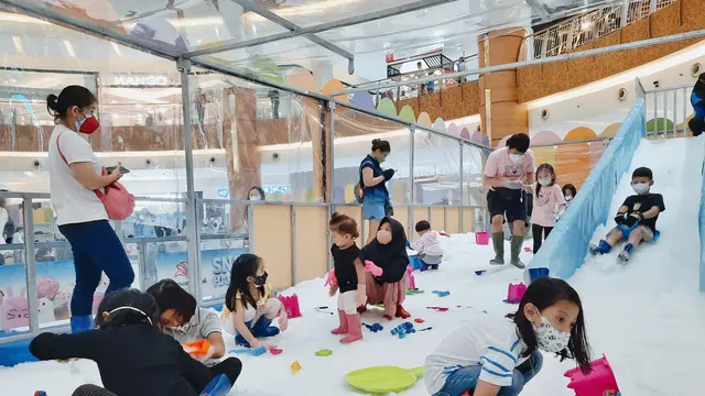 Keseruan anak-anak mengisi waktu libur sekolah dengan bermain salju di Summarecon Mall Serpong, Tangerang. (Liputan6.com/Pramita Tristiawati)