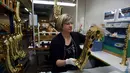 Pekerja mengecek body saksofon di pabrik Selmer Saxophone, Mantes-la-Ville, (17/1). Saksofon biasanya terbuat dari logam dan dimainkan menggunakan single-reed seperti klarinet. Saksofon. (AFP Photo/Alain Jocard)