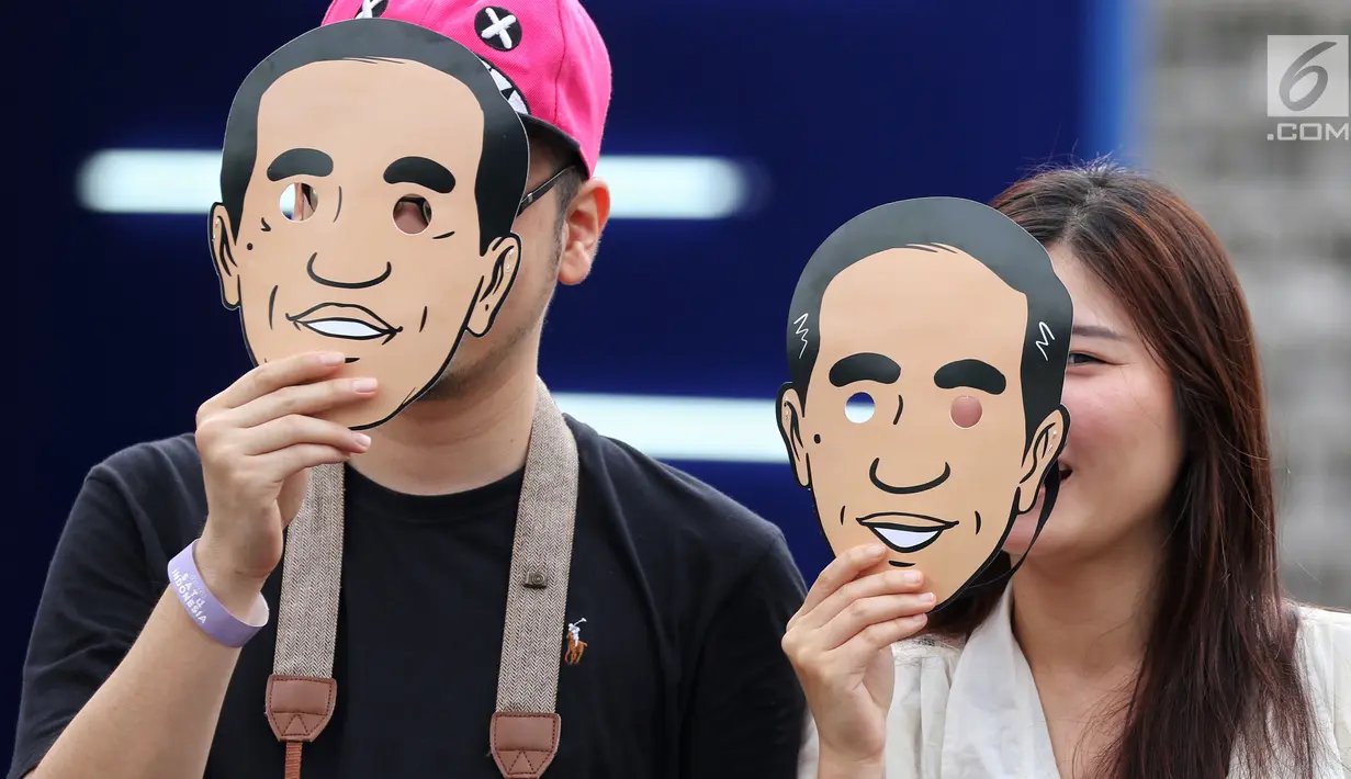 Dua pendukung calon Presiden no urut 01 Joko Widodo berpose mengenakan topeng berwajah Jokowi di Istora Senayan, Jakarta, Minggu (10/3). Acara Festival Satu Indonesia dibuka Presiden Jokowi. (Liputan6.com/Johan Tallo)