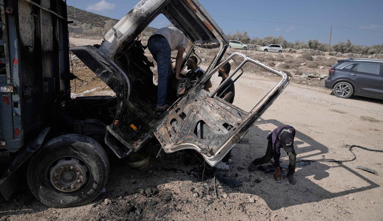 Jumlah ini menjadi yang tertinggi sejak pencatatan dimulai pada 2006. Tampak dalam foto, warga Palestina memeriksa kerusakan di kawasan industri setelah serangan yang dilakukan oleh pemukim Israel pada hari sebelumnya di desa Beit Lid, dekat Tulkarm, di Tepi Barat, Rabu 12 November 2025. (AP Photo/Majdi Mohammed)