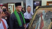 Gubernur DKI Anies Baswedan mendapat lukisan saat meresmikan penetapan nama jalan, gedung, dan zona di Jakarta dengan nama tokoh-tokoh Betawi di Setu Babakan, Jaksel. (Liputan6.com/Winda Nelfira)