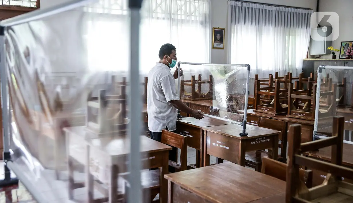 Petugas menyiapkan ruangan kelas yang akan digunakan di SMP N 115 Jakarta, Jumat (21/5/2021). Seleksi PPDB DKI Jakarta tahun ini akan dibagi menjadi empat bagian yakni jalur prestasi, jalur afirmasi, jalur zonasi, dan jalur pindah tugas orangtua dan anak guru. (Liputan6.com/Faizal Fanani)