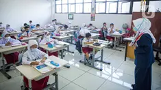 Guru memberi materi kepada siswa saat pembelajaran tatap muka (PTM) di SDN 01 Pondok Labu, Jakarta, Senin (3/1/2022). Pemprov DKI Jakarta menggelar pembelajaran tatap muka (PTM) setiap hari dengan jumlah siswa setiap kelas mencapai 100 persen dari kapasitas. (Liputan6.com/Faizal Fanani)