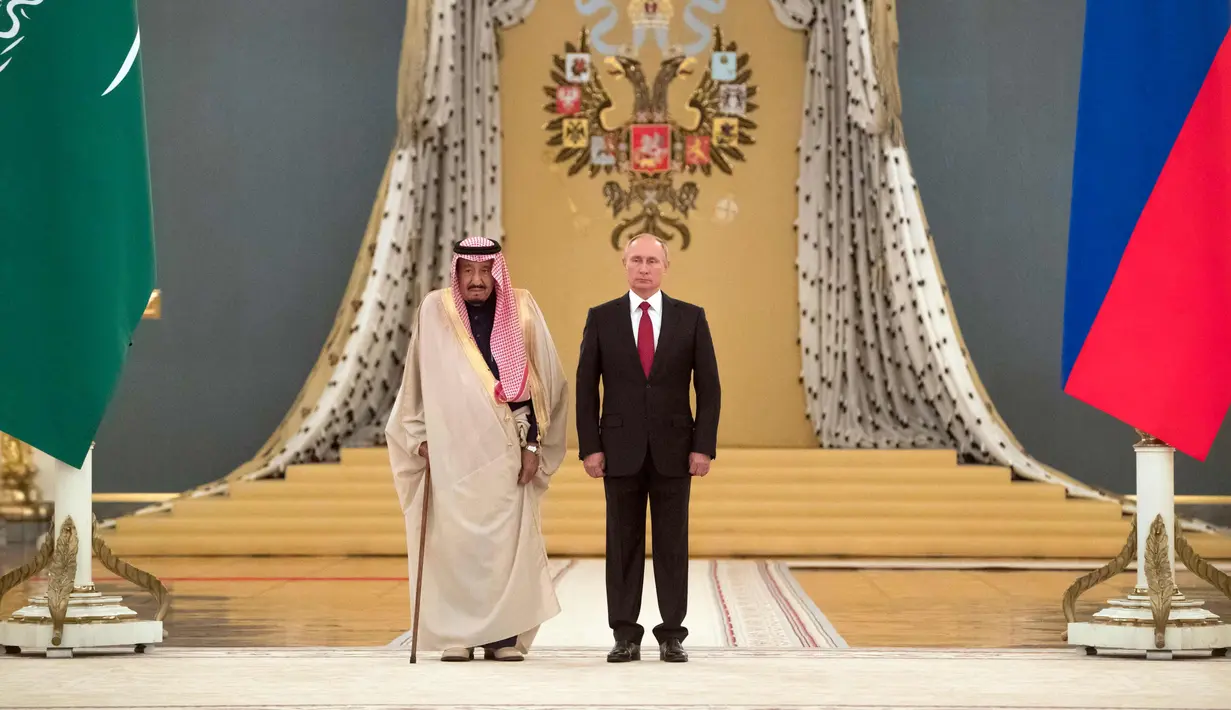  Presiden Rusia, Vladimir Putin dan Raja Arab Saudi Salman bin Abdulaziz Al Saud mendengarkan lagu kebangsaan di Kremlin, Moskow, Rusia (5/10). Raja Salman tercatat sebagai raja Saudi pertama yang menjejakkan kaki ke Rusia. (AP Photo/Pavel Golovkin)