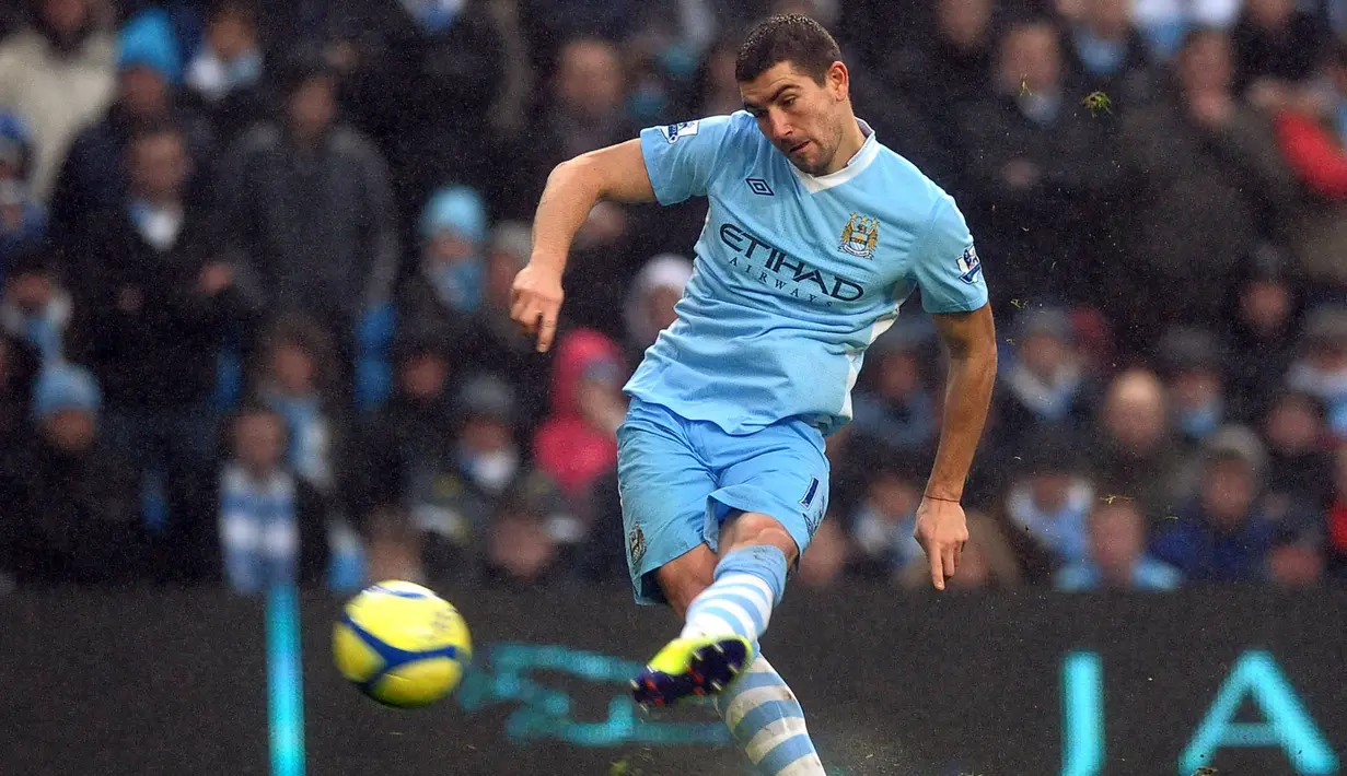 Pemain Manchester City, Aleksandar Kolarov mencetak gol pertama timnya ke gawang Manchester United melalui tendangan bebas pada laga putaran ketiga Piala FA 2011/2012 yang berlangsung di Etihad Stadium, Manchester, 8 Januari 2012. (AFP/Paul Ellis)