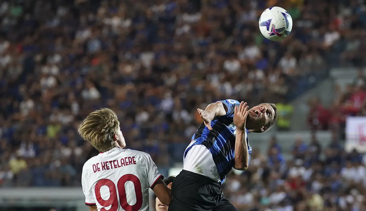 Gelandang AC Milan Charles De Ketelaere berebut bola dengan gelandang Atalanta Mario Pasalic pada laga pekan kedua Serie A 2022/2023 di Stadion Atleti Azzurri d'Italia, Senin (22/8/2022) dini hari WIB. AC Milan hanya mampu bermain imbang 1-1 di kandang Atalanta. (Spada/LaPresse via AP)