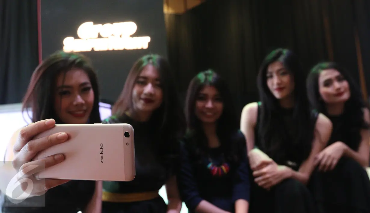 Sejumlah model berfoto sambil memeragakan telepon pintar Oppo F3 saat peluncuran di Jakarta, Kamis (04/05). Oppo F3 dibekali kamera utama beresolusi 13MP dengan Optical Image Stabilization (OIS), LED flash. (Liputan6.com/Herman Zakharia)
