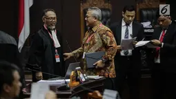 Ketua KPU Arief Budiman (kanan) berbincang dengan pemohon Ketua Tim Hukum Prabowo-Sandiaga, Bambang Widjojanto sebelum sidang sengketa Pilpres 2019 di Gedung MK, Jakarta, Selasa (18/6/2019). Sidang beragendakan mendengarkan jawaban dari termohon. (Liputan6.com/Faizal Fanani)