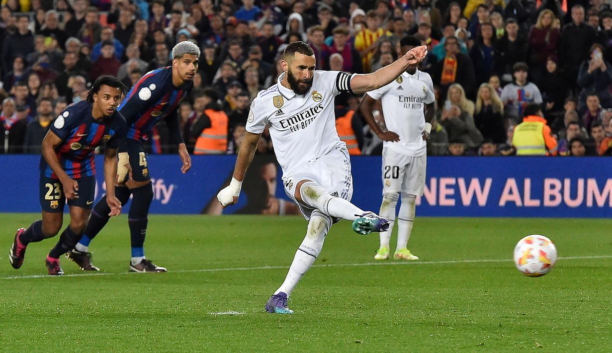Striker Real Madrid, Karim Benzema mencetak gol ketiga timnya ke gawang Barcelona melalui eksekusi penalti pada laga leg kedua semifinal Copa del Rey 2022/2023 di Camp Nou Stadium, Barcelona, Kamis (6/4/2023) dini hari WIB. (AFP/Pau Barrena)