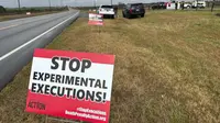 Aktivis anti-hukuman mati memasang tanda di sepanjang jalan menuju Lembaga Pemasyarakatan Holman di Atmore, Alabama, menjelang jadwal eksekusi Kenneth Eugene Smith dengan gas nitrogen pada Kamis, 25 Januari 2024. (Kim Chandler/AP)