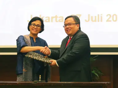 Menteri Keuangan yang baru Sri Mulyani (kiri) bersalaman dengan mantan Menkeu Bambang Brodjonegoro saat serah terima jabatan di Jakarta, Rabu (27/7). Bambang Brodjonegoro kini digeser menjadi Kepala Bappenas. (Liputan6.com/Angga Yuniar)