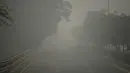 Kendaraan bermotor menembus kabut asap pekat yang menyelimuti jalan di New Delhi, Minggu (3/10/2019). Ibu Kota dari India tersebut sedang dilanda polusi udara yang sangat buruk sekaligus beracun pekan ini. (Photo by Sajjad  HUSSAIN / AFP)