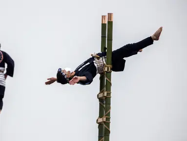 Anggota Asosiasi Pelestarian Pemadam Kebakaran Edo melakukan teknik pemadam kebakaran tradisional Jepang saat latihan pemadam kebakaran Tahun Baru di Tokyo, Jepang, 6 Januari 2022. (Behrouz MEHRI/AFP)