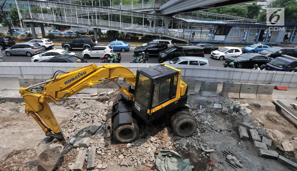 Pekerja menggunakan alat berat saat menyelesaikan proyek penataan ulang trotoar Jalan Jenderal Sudirman, Jakarta, Kamis (25/10). Proyek tersebut mempersempit jalur pejalan kaki dan menyebabkan kemacetan kendaraan. (Merdeka.com/Iqbal Nugroho)