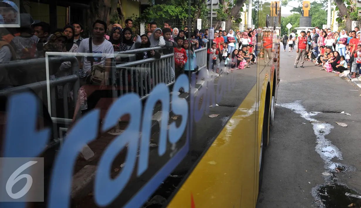 Warga mengantre naik Bus City Tour Jakarta di Jakarta, Sabtu (9/7). Masyarakat Jakarta memanfaatkan libur Lebaran dengan menumpang bus gratis untuk mengunjungi ikon Ibu kota seperti Patung Selamat Datang, Mesjid Istiqlal.  (Liputan6.com/Johan Tallo)