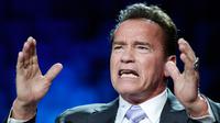 Aktor AS, Arnold Schwarzenegger berbicara pada forum KTT One Planet Summit di Paris, Selasa (12/12). Mantan Gubernur California itu mencuri perhatian dengan dua cincin di jari yang salah satunya bermotif tengkorak warna perak. (AP Photo/Christophe Ena)