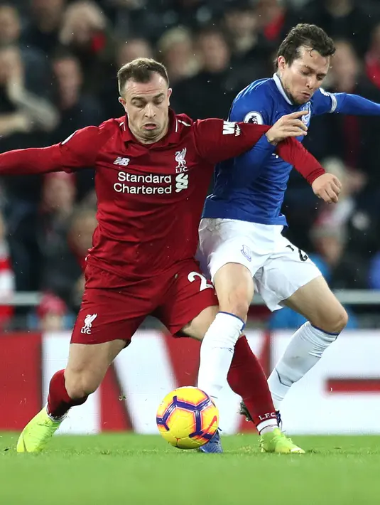 Gelandang Liverpool, Xherdan Shaqiri berebut bola dengan gelandang Everton, Bernard selama pertandingan Liga Inggris di Anfield Stadium (2/12). Liverpool menang tipis 1-0 atas Everton. (AP Photo / Jon Super)