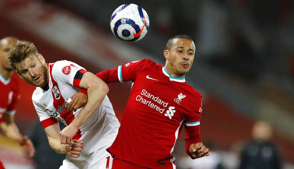Penyerang Liverpool, Thiago Alcantara, duel udara dengan pemain Southampton, Nathan Redmond, pada laga Liga Inggris di Stadion Anfield, Minggu (9/5/2021). Liverpool menang dengan skor 2-0. (Phil Noble/Pool via AP)