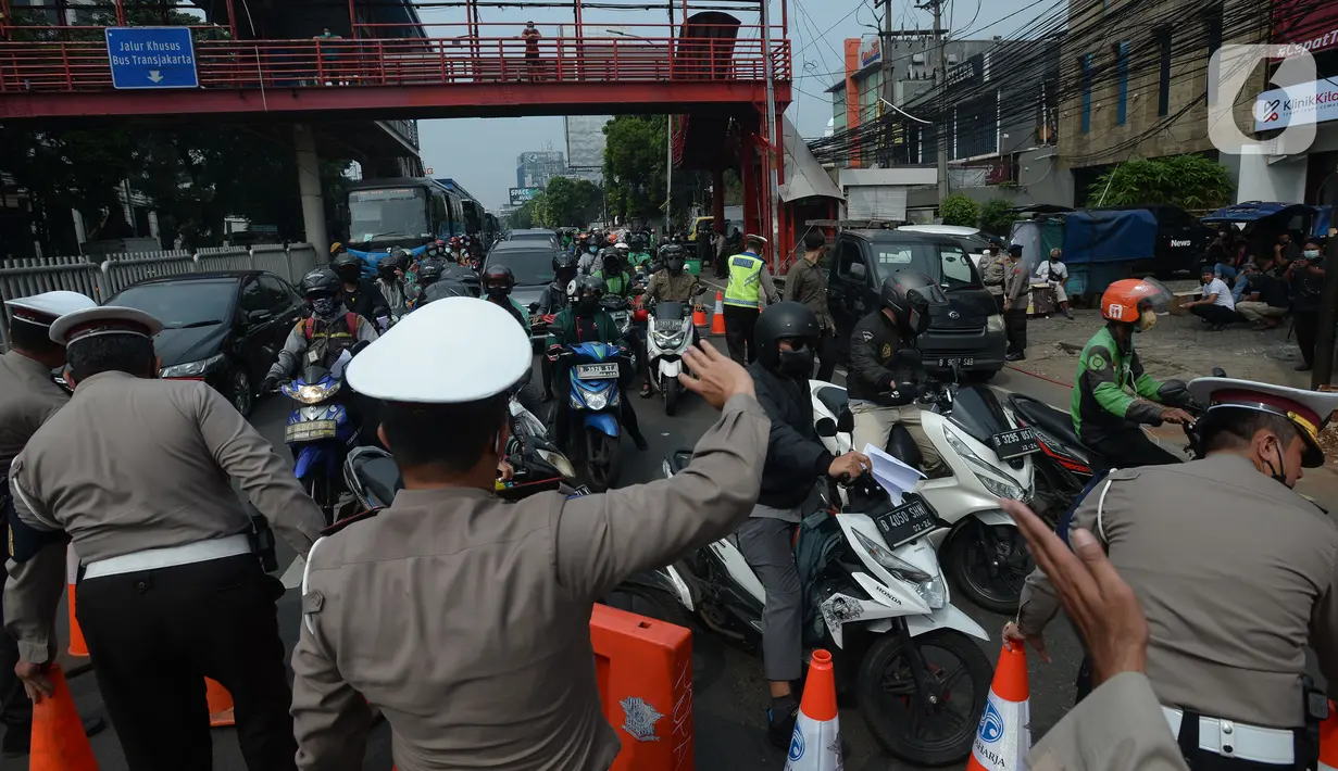 Petugas mengarahkan kendaraan saat penyekatan di ruas jalan Mampang Prapatan, Jakarta, Kamis (15/7/2021). Mampang menjadi salah satu jalan yang masuk dalam penyekatan baru pada Pemberlakuan Pembatasan Kegiatan Masyarakat (PPKM) darurat di Ibu Kota. (merdeka.com/Imam Buhori)