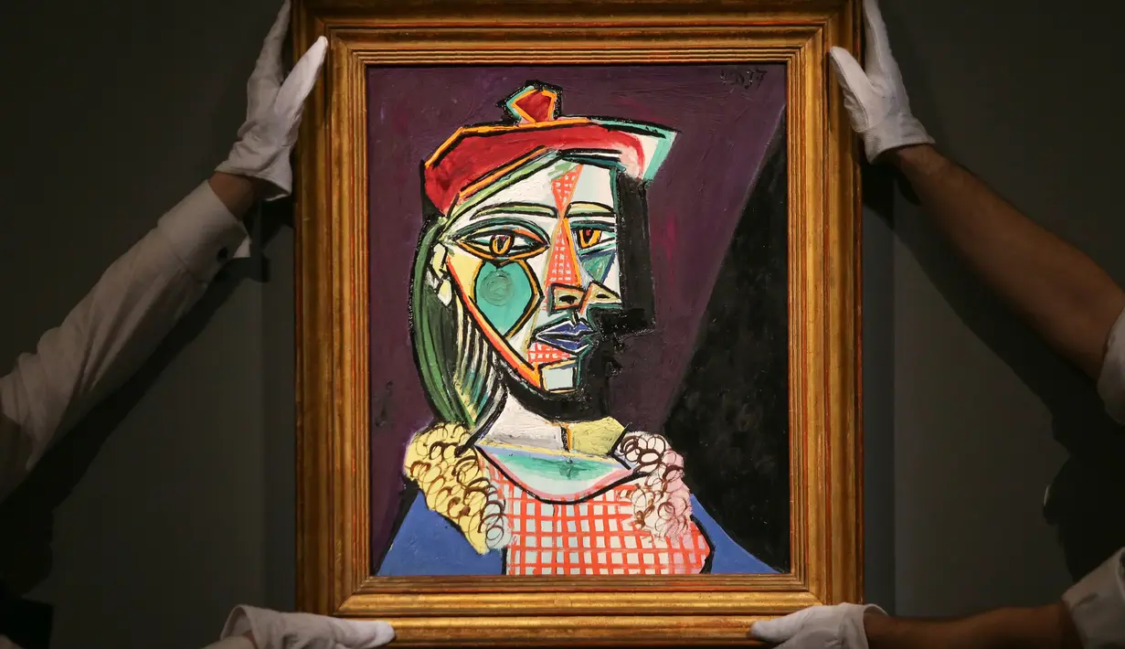 Petugas rumah lelang Sotheby menata lukisan Pablo Picasso bertema Marie-Therese Walter pada sesi pemotretan di London, Rabu (22/2). Lukisan yang akan dilelang ini diperkirakan nilainya mencapai US$ 50 juta atau Rp 685 miliar. (Daniel LEAL-OLIVAS/AFP)