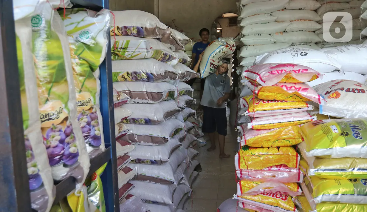 Buruh membawa karung beras di pasar induk beras Cipinang, Jakarta, Sabtu (16/5/2020). Mengantisipasi penyebaran Covid-19 sejumlah kuli dan buruh di Pasar Induk beras Cipinang diberi obat herbal mentah untuk meredakan panas. (Liputan6.com/Herman Zakharia)