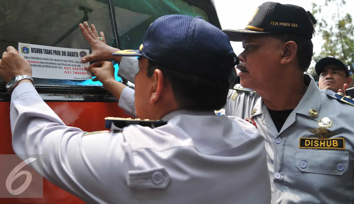 Petugas Dishub menempelkan stiker saat menggelar operasi uji kelengkapan surat kendaraan angkutan umum di Terminal Pasar Minggu, Senin (26/10/2015). Kegiatan ini untuk meningkatkan kapasitas pelayanan terhadap angkutan umum. (Liputan6.com/Gempur M Surya)