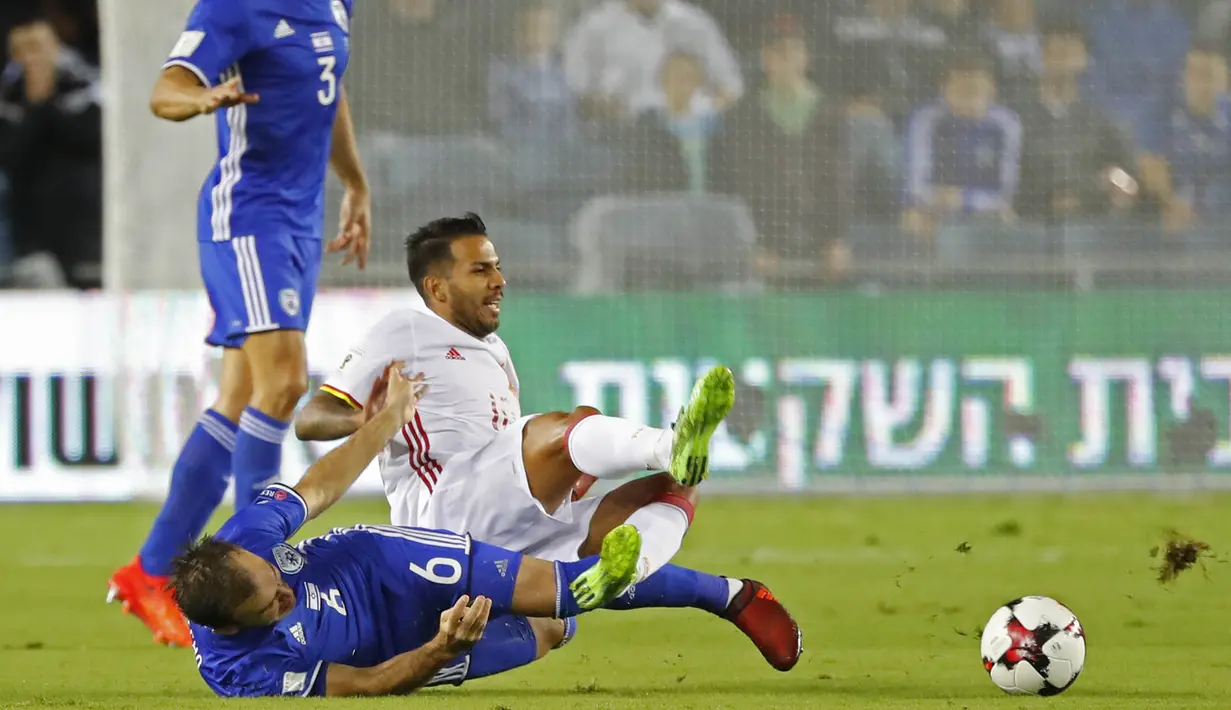Gelandang Spanyol, Jonathan Viera, dijatuhkan gelandang Israel, Bibras Natcho, pada laga kualifikasi Piala Dunia 2018 di Stadion Teddy, Yerusalem,Senin (9/10/2017). Israel kalah 0-1 dari Spanyol. (AFP/Jack Guez)