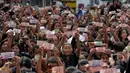 Rakyat Thailand memperlihatkan uang bergambar Raja Thailand Bhumibol Adulyadej saat menunggu pemindahan jenazah Bhumibol dari rumah sakit menuju Grand Palace, Bangkok, Thailand, Jumat (14/10). (REUTERS / Chaiwat Subprasom)