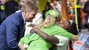 Ratu Maxima (Tengah) dipeluk oleh seorang pemberi selamat di samping suaminya Raja Willem-Alexander dari Belanda (kiri) selama perayaan Hari Raja di Rotterdam, pada 27 April 2023. (Robin van Lonkhuijsen / ANP / AFP)
