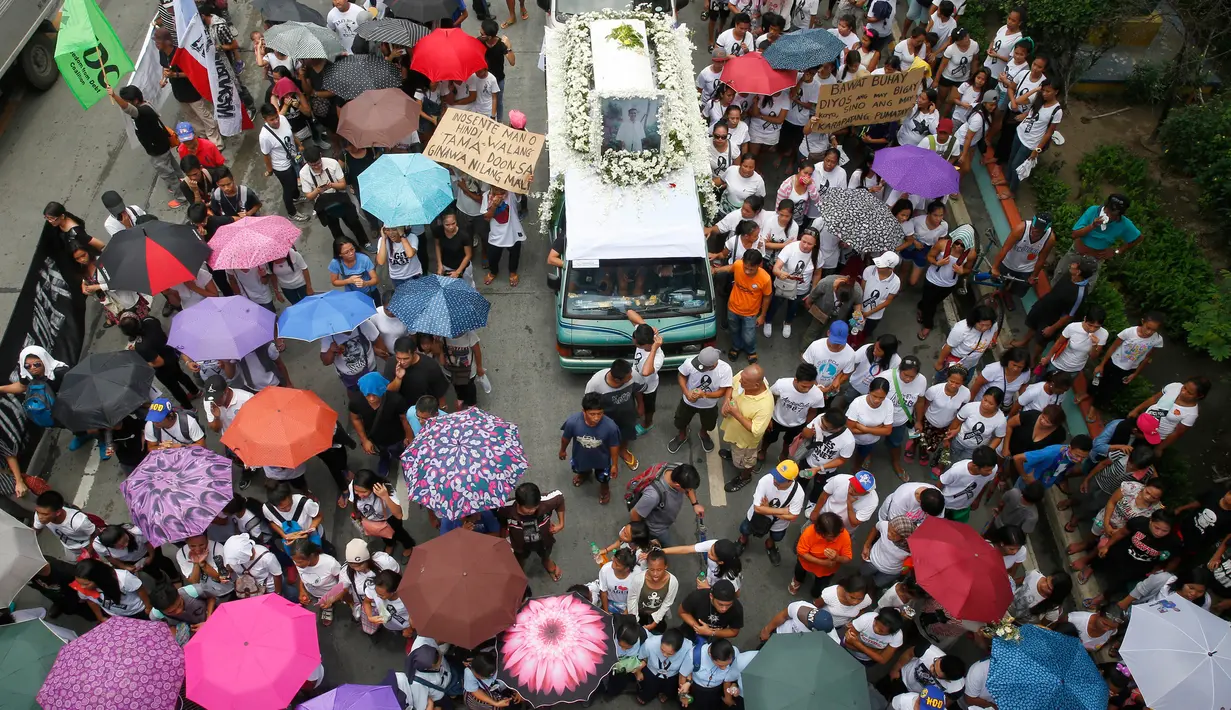 Para pemrotes mengiringi mobil yang membawa jenazah Kian Loyd delos Santos di Caloocan, Filipina (26/8). Kian Loyd adalah remaja usia 17 tahun korban tembak mati dari pasukan anti narkoba pemerintahan Duterte. (AP Photo/Bullit Marquez)