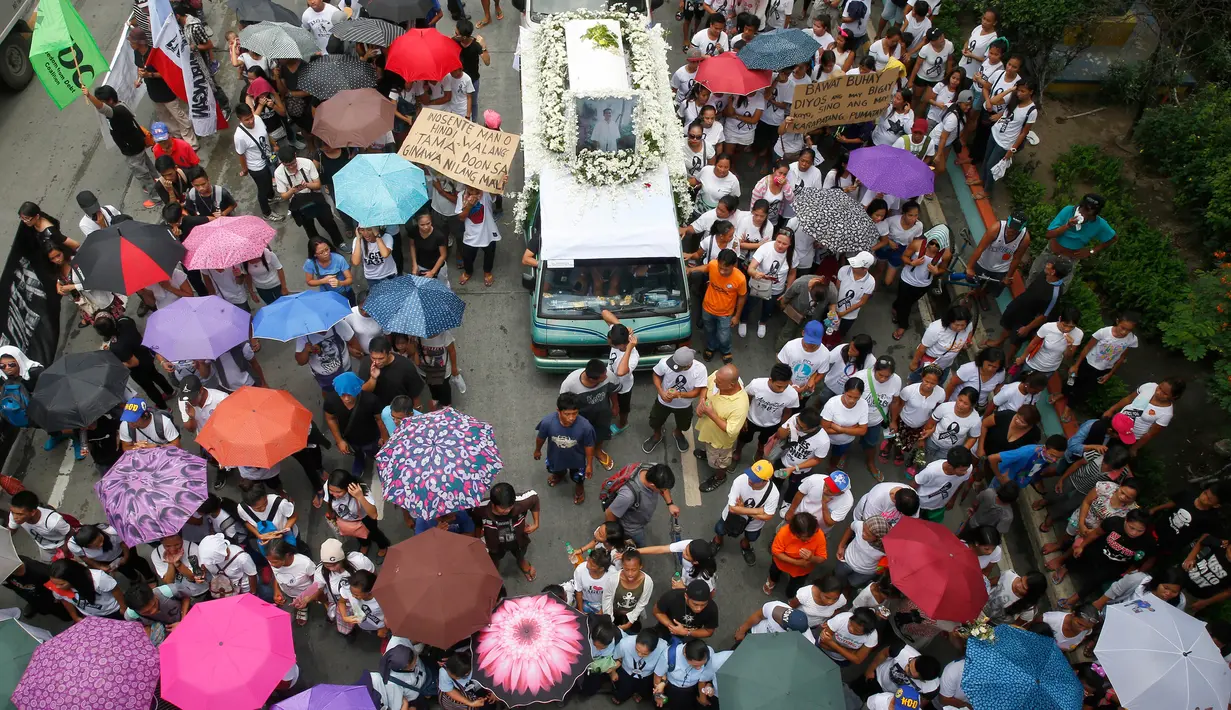 Para pemrotes mengiringi mobil yang membawa jenazah Kian Loyd delos Santos di Caloocan, Filipina (26/8). Kian Loyd adalah remaja usia 17 tahun korban tembak mati dari pasukan anti narkoba pemerintahan Duterte. (AP Photo/Bullit Marquez)