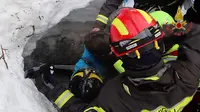 Tim penyelamat berhasil menolong seorang anak dari hotel italia yang tertimbun salju (Vigili del Fuoco/AFP)
